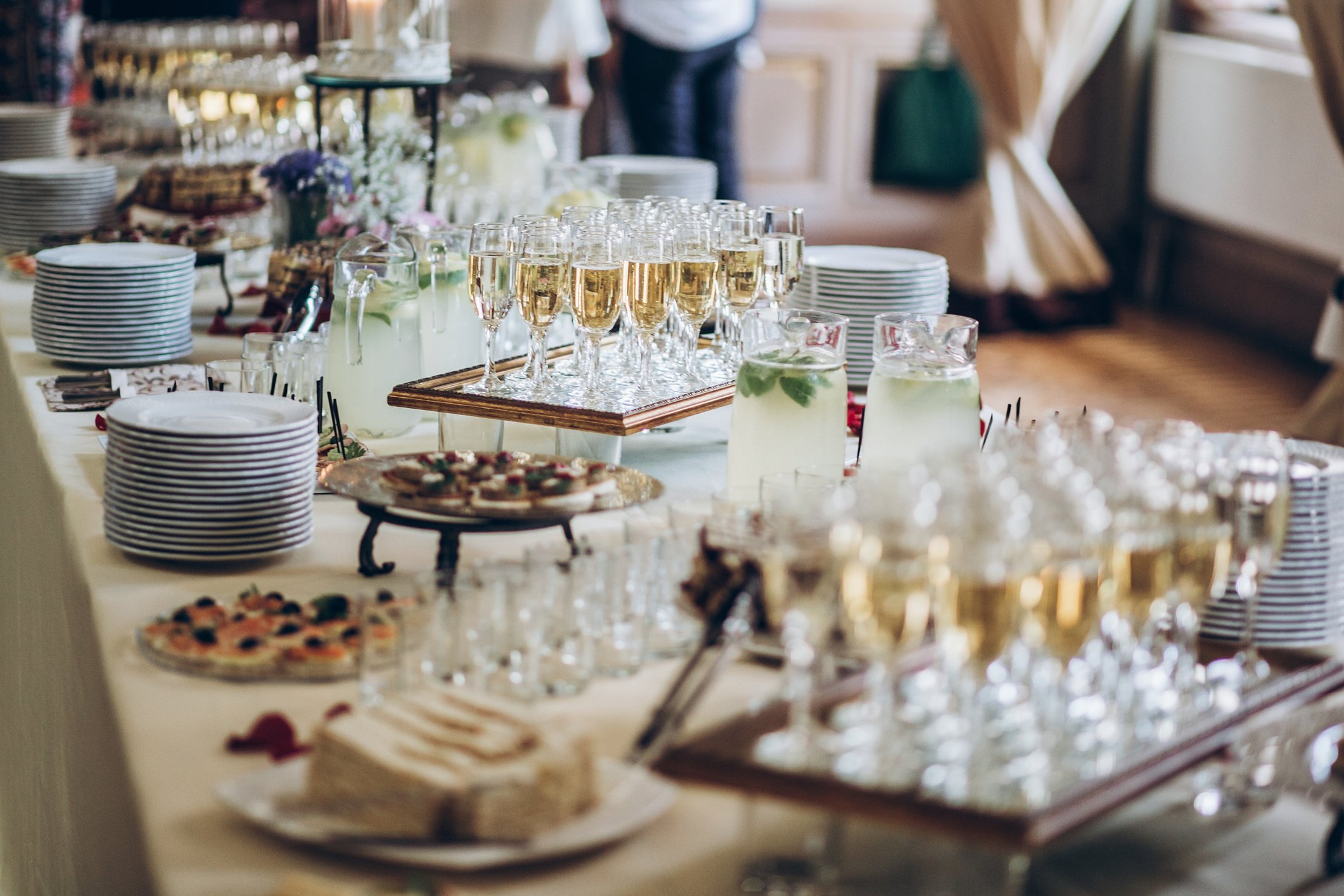 stylish champagne glasses and food appetizers on table at wedding reception.